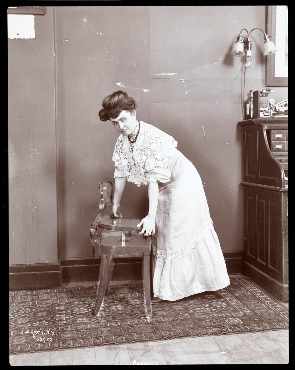 Kobieta demonstrująca specjalne krzesło w Aeolian Co., Nowy Jork, 1906 lub 1907 (odbitka żelatynowa) autorstwa Byron Company