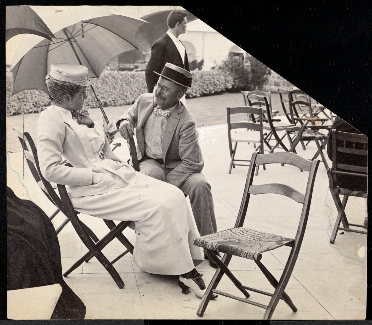 Mężczyzna i kobieta siedzą na zewnątrz na składanych krzesłach z kobietą trzymającą parasolkę, Narragansett, Rhode Island, 1891 (srebrny odbitka żelatynowa) autorstwa Byron Company