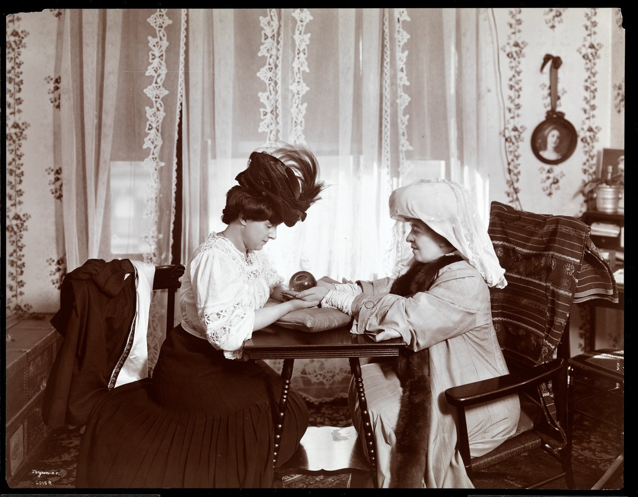 Pani Leslie Carter siedząca z kobietą czytającą kryształową kulę, 1904 (srebrny odbitka żelatynowa) autorstwa Byron Company