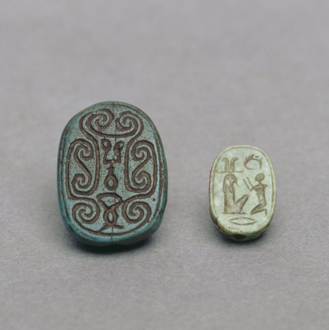 (L-R) Egipski fajansowy amulet skarabeusza, Drugi Okres Przejściowy, XIII-XVII dynastia, ok. 1650 pne; zielony amulet skarabeusza skalenia, okres późny, 26 dynastia, ok. 600 pne autorstwa Egyptian