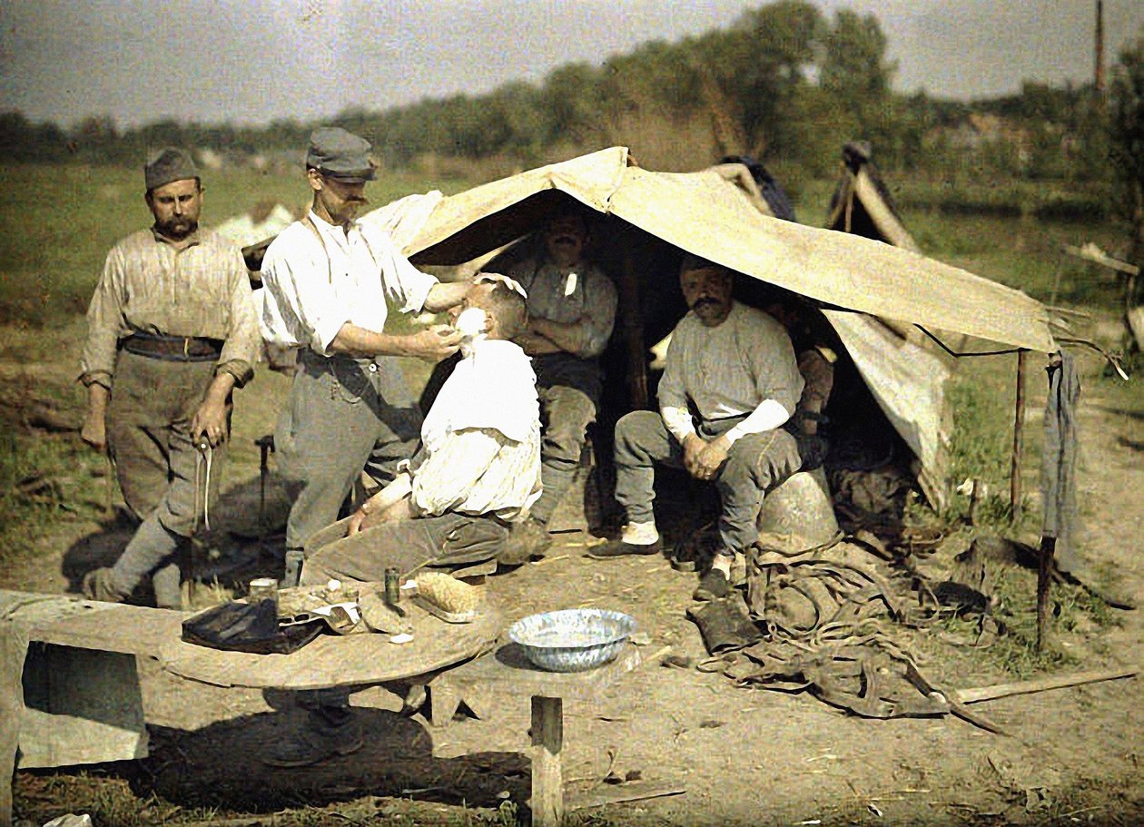 Żołnierz golony przez fryzjera we francuskim obozie wojskowym, Soissons, Aisne, Francja, 1917 (autochrom) autorstwa Fernand Cuville